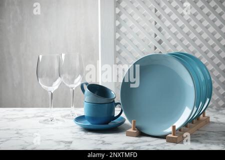 Set of clean dishware and glasses on white marble table Stock Photo