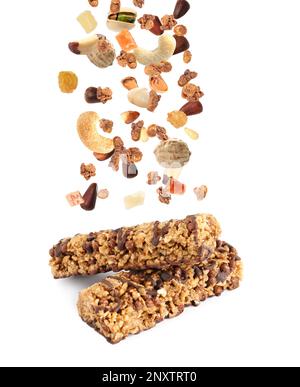 Tasty protein bars and granola with nuts and dried fruits falling on white background Stock Photo