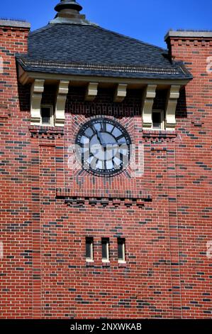 Old clock tower, on the Clinchfield Railroad Depot, Kingsport, Tennessee, has grey face and black roman numeral numbers.  Clock sits on side of depot' Stock Photo