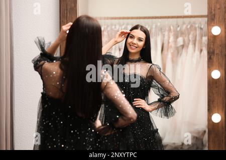 Woman trying on dress in clothing rental salon Stock Photo