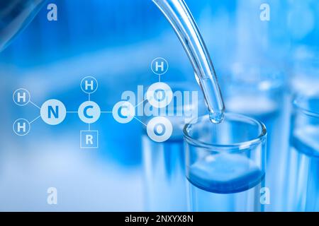 Amino Acids chemical formula, illustration. Dripping reagent into test tube with liquid sample, closeup. Stock Photo