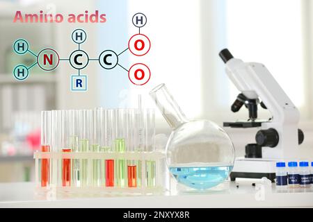 Amino Acids chemical formula, illustration. Laboratory glassware and microscope on table indoors Stock Photo