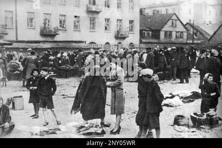 In the early stages of WW2 the Jews in nazi occupied europe were rounded up and forced into crowded ghettoes. When the decision was made to kill them all they were deported to extermination centres to be murdered. This image shows the Jojne Pilcer Market at the intersection of Łagiewnicka and Berliński streets. Here the people bargained their last few items for food. Stock Photo