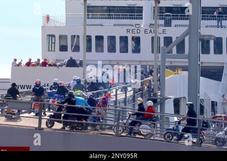 Vespas, Lambrettas, Royal Alloys, and replica classic scooters swarm upon the “Red Eagle” ferry, bound for the I-O-W scooter rally August 2022. Stock Photo