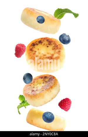 Delicious cottage cheese pancakes, mint and berries falling on white background Stock Photo