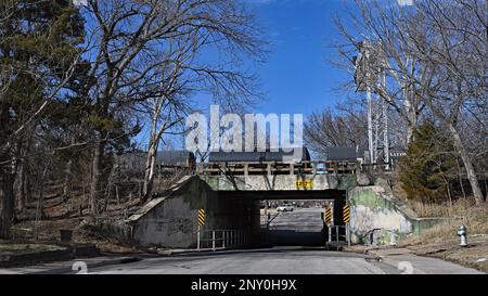 EMPORIA, KANSAS - MARCH 1, 2023 Burlington Northern Santa Fe (BNSF) train hauling a string of tank cars filled with corn syrup heads east at the Congress street overpass which is in need of infrastructure repair as the concrete walls are failing. Stock Photo