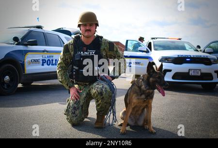 NAS PATUXENT RIVER, Maryland (Feb. 8, 2023) - Master-at Arms 3rd Class Colton Farmer and Military Working Dog (MWD) Georgina perform a perimeter sweep during a suspicious package drill during the Citadel Shield/Solid Curtain (CS/SC) Exercise 2023.     MWDs and their handlers are an integral part of Naval Security Forces, providing unique capabilities to defend bases by detecting dangerous materials. Like other highly specialized pieces of equipment, MWDs supplement and enhance the capabilities of military security forces. When integrated into existing military security forces, MWD teams enable Stock Photo