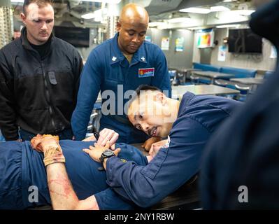 230125-N-QF023-1101  PHILLIPINE SEA (Jan. 25, 2023) Senior Chief Hospital Corpsman Kimemanuel Suarez, from Los Angeles, California, checks for a pulse during medical training aboard Arleigh Burke-class guided-missile destroyer USS Benfold (DDG 65). Benfold is assigned to Commander, Task Force (CTF) 71/Destroyer Squadron (DESRON) 15, the Navy’s largest forward-deployed DESRON and the U.S. 7th Fleet’s principal surface force. Stock Photo