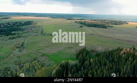 Calm picturesque landscape. Clip.Fields with tall colorful houses, grass and small residential buildings and roads. High quality 4k footage Stock Photo