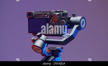 Sony camera accessories. Action. A rotating tripod for shooting with an attached camera on a purple background. High quality 4k footage Stock Photo