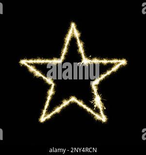 Close-up on a Star made of yellow sparks on a black background. Stock Photo