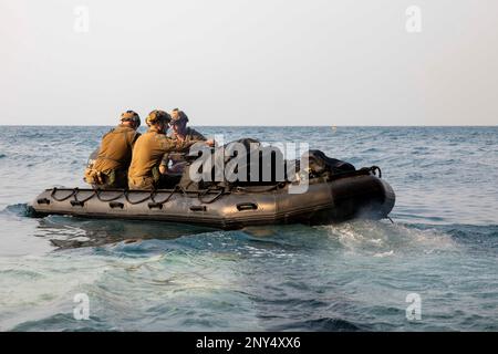 Marines assigned to 1st Reconnaissance, 13th Marine Expeditionary Unit (MEU), depart the welldeck of amphibious assault ship USS Makin Island (LHD 8) in a combat rubber rating craft (CRRC), Feb. 25, 2023 in the Gulf of Thailand. CRRC missions include over the horizon covert and overt insertion and extraction, diving, submarine, airborne operations and other specialized missions requiring a compact inflatable craft capable of transporting Marines and material with speed and stealth. The Makin Island Amphibious Ready Group, comprised of amphibious assault ship USS Makin Island (LHD 8) and amphib Stock Photo