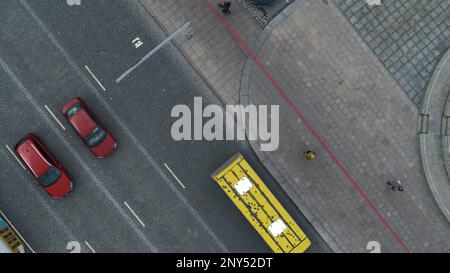 Top view of city road with traffic of cars. Stock footage. Urban highway with traffic of cars and people. Cars drive on city roads on cloudy day. Stock Photo