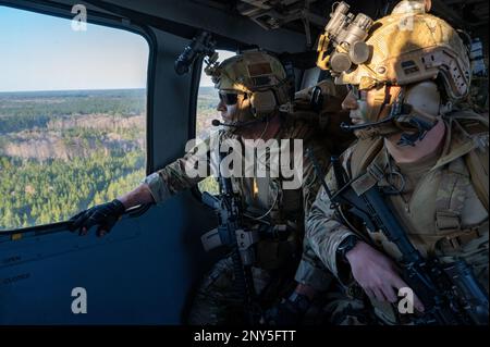 Staff Sgt. Dennis McClain, 146th Air Support Operations Squadron, Oklahoma City Air National Guard, and Senior Airman Travis Jackson, 165th ASOS, Georgia Air National Guard, Tactical Control Party Airmen, look out from the back of an HH-60G Pave Hawk helicopter as it flies over Savannah, Georgia, during exercise Sunshine Rescue Jan. 23, 2023. This exercise trains Airmen on leading edge Combat Search and Rescue capabilities for next generation warfighting. During this exercise, Tactical Air Control Party and Pararescue Airmen will use advanced communication and command and control technologies Stock Photo