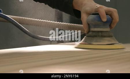 Close-up polishing of wooden board. Creative. Polishing with special machine on wood. Polished surfaces of wooden board by machine tool. Stock Photo