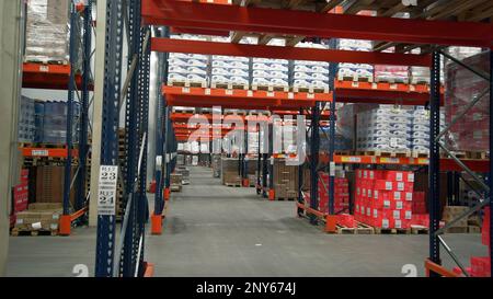 Poland, Warsaw- September 14, 2022: Large room with goods in stock. Creative. Large warehouse with boxes and lots of shelves. Corridors of shelves wit Stock Photo