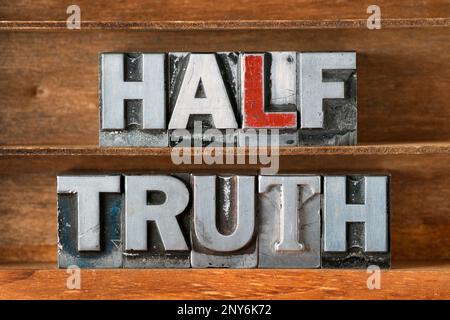 half truth phrase made from metallic letterpress type on wooden tray Stock Photo