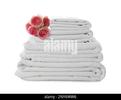 Stack of towels and bed sheets with roses on white background Stock Photo