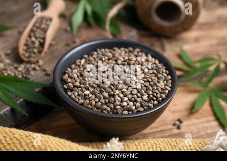 Bowl with hemp seeds on wooden table, closeup Stock Photo