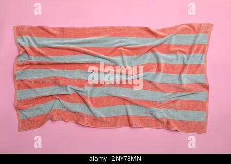Crumpled striped beach towel on pink background, top view Stock Photo