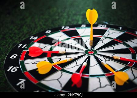 Close up shot of a dart board. Darts arrow Missing the target on a dart board during the game. Darts red and yellow. Stock Photo