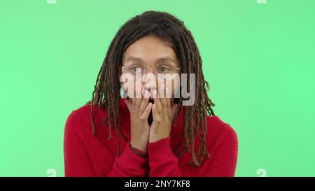 Wow, shock and surprise with a black man in studio on a green screen background showing disbelief. Face, hands and shocked with a surprised young male Stock Photo