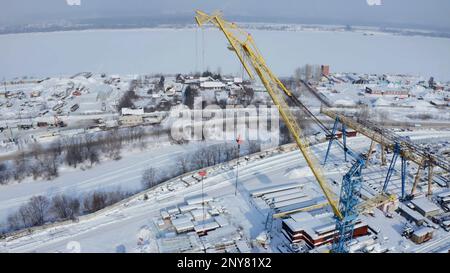 Industrial aerial background with the crane at the construction site. Clip. Winter frozen landscape, concept of heavy machinery Stock Photo