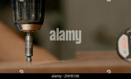 Close up of a man carpenter using screwdriver while working with a wooden product. Creative. Woodwork at the workshop Stock Photo