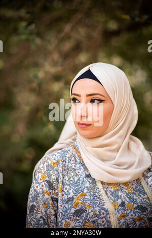 Pensive Muslim woman looking away outdoors Stock Photo