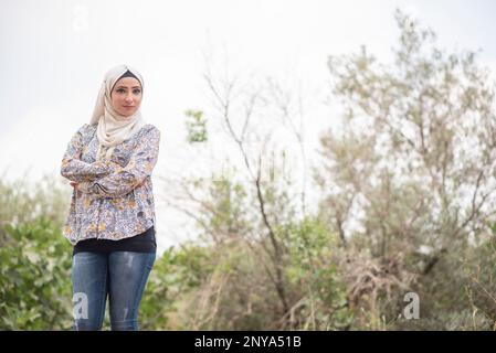 Beautiful Muslim woman looking away outdoors Stock Photo