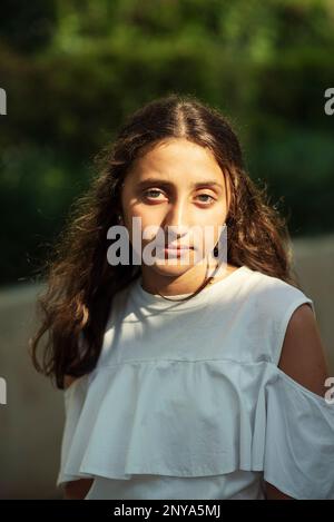 Serious teenage girl looking at camera outdoors Stock Photo