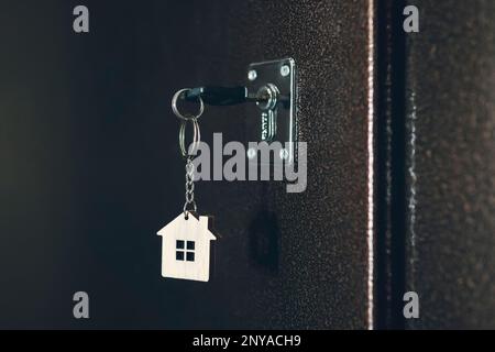 process of opening the front door to the apartment. House model and key in house door. Real estate agent offer house, property insurance and security, Stock Photo