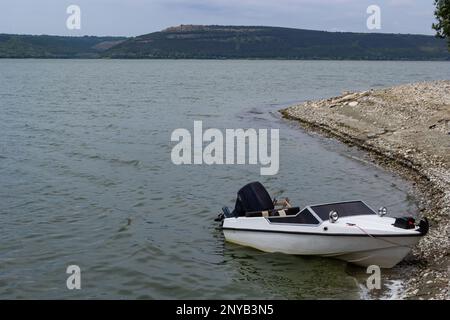 the boat stands on the bank of the river. Means of transportation on water. Stock Photo