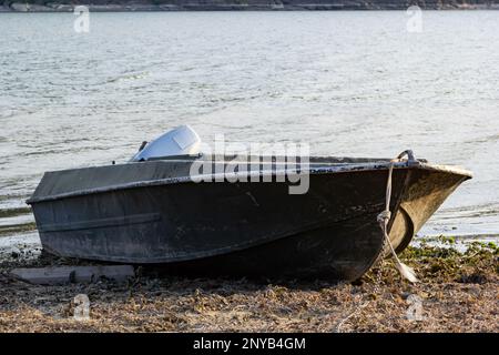 the boat stands on the bank of the river. Means of transportation on water. Stock Photo