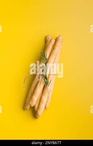Italian grissini bread sticks on the yellow background. Top view. Stock Photo