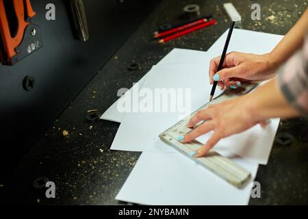 Female designer near big paper sheet with project plan in office