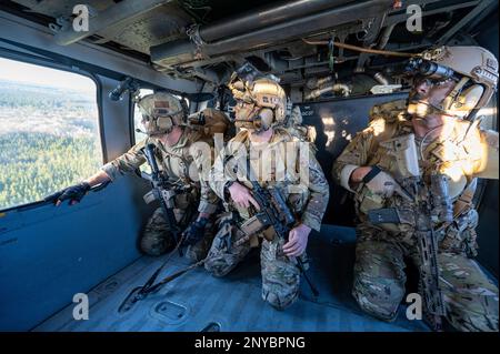 Staff Sgt. Dennis McClain, 146th Air Support Operations Squadron, Oklahoma City Air National Guard, Senior Airman Travis Jackson, and Capt. Ryan McCary, 165th ASOS, Georgia Air National Guard, Tactical Control Party Airmen, look out from the back of an HH-60G Pave Hawk helicopter as it flies over Savannah, Georgia, during exercise Sunshine Rescue Jan. 23, 2023. This exercise trains Airmen on leading edge Combat Search and Rescue capabilities for next generation warfighting. During this exercise, Tactical Air Control Party and Pararescue Airmen will use advanced communication and command and co Stock Photo