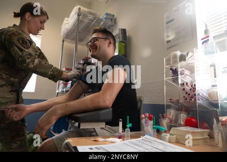 Staff Sgt. Season Bachman, 379th Expeditionary Medical Support Squadron laboratory technician, puts a tourniquet on Airman 1st Class Mason Amadio, 8th Expeditionary Airlift Squadron weapons systems controller, prior to a platelet donation, Jan. 24, 2023, at Al Udeid Air Base, Qatar. Since platelets only last for 5-7 days, there is a continuous need for donors to participate in AUAB’s apheresis program. The platelets collected are shipped to two locations within the U.S. Central Command Area of Responsibility. Stock Photo