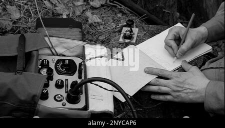 Infantry Army Soldier In World War II using Portable Radio Transceiver In Trench Entrenchment In Forest. . Headphones And Telegraph Key. Close Up Stock Photo