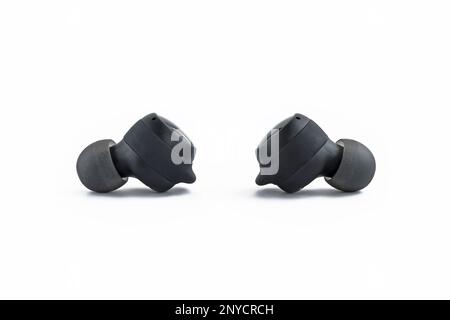 Small wireless black headphones isolated on white background. Stock Photo