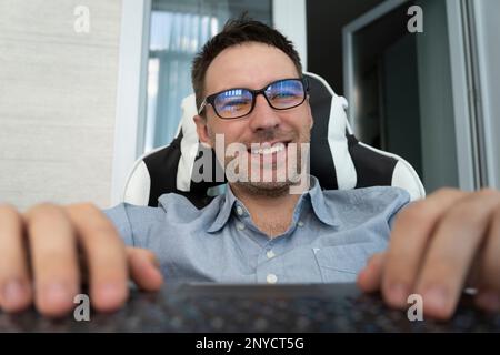 Professional copywriter working freelance project, typing on keyboard. Happy businessman using laptop computer, planning start up, sitting in modern o Stock Photo