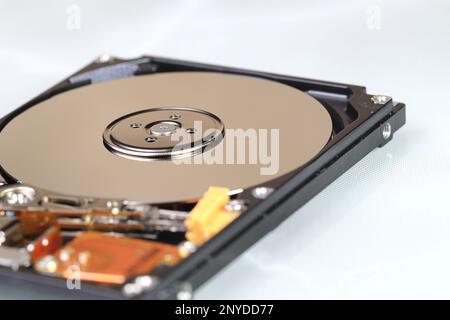 Close up view of internal computer hard drive 2.5" SAS, can see disk surface and head with shallow focus isolated on white background. Stock Photo