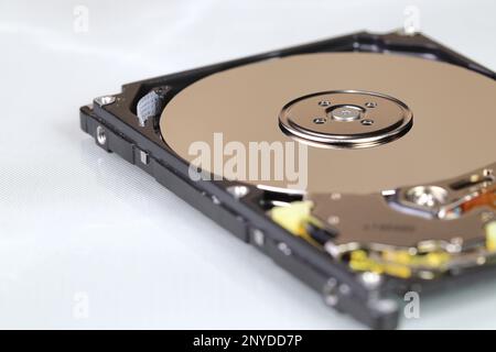 Close up view of internal computer hard drive 2.5" SAS, can see disk surface and head with shallow focus isolated on white background. Stock Photo