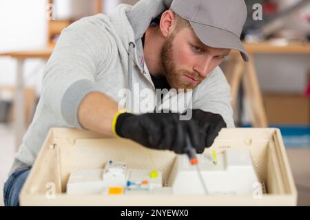 young energetic male tech or engineer repairs electronic equipment Stock Photo
