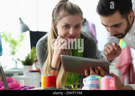 Professional tailors work on project using tablet in fashion design studio Stock Photo