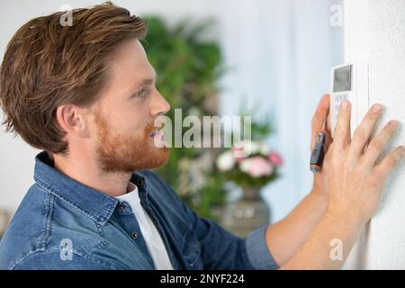 young male electrician installing security system Stock Photo