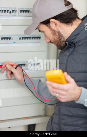 electrician installing energy saving meter Stock Photo