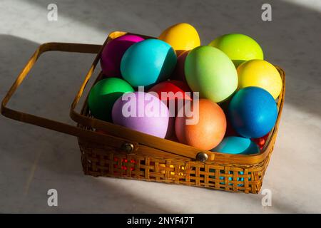 Basket Full of Colorful Dyed Easter Eggs in Rainbow Colors for the Spring Holiday Stock Photo