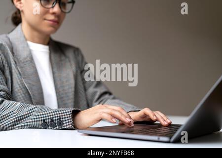Business woman working on her laptop while sitting at desk. Stock Photo