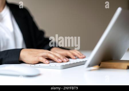 Female business person using wireless keyboard and digital tablet. Stock Photo